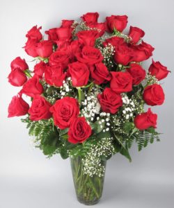 Three dozen spectacularly gorgeous red roses artistically arranged in a dazzling glass vase. 