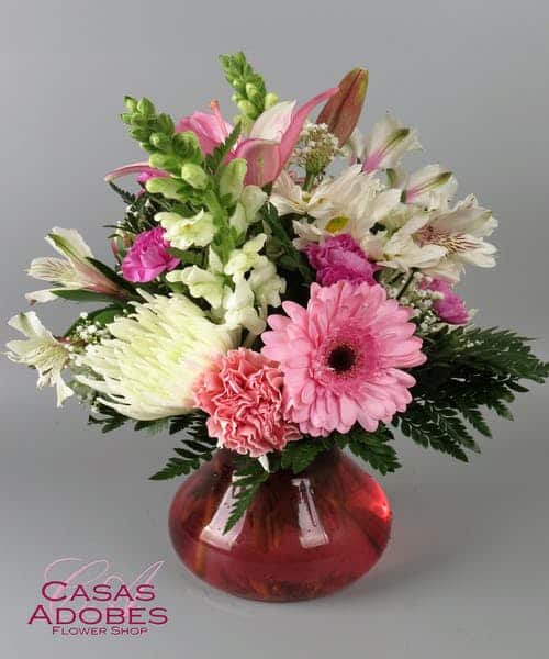 This bouquet blossoms with love to make your occasion brighter with each hand-picked flower! Pink gerbera daisies, pink lilies, and pink carnations are accented with white snapdragons, white alstroemeria and and baby's breath. Presented in a berry pink glass vase to give this design a head-to-toe finishing touch!