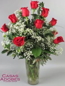 One dozen of our finest long stem red roses carefully hand selected and arranged in all their natural beauty in a glass vase with babies breath and lush greenery