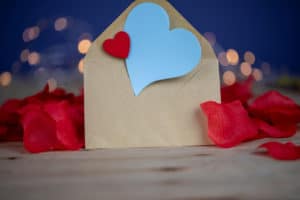 Brown envelope with blue heart and red rose petals