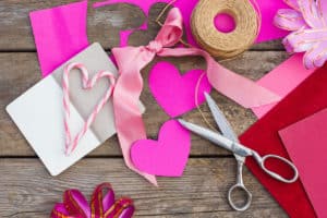 Pink arts and craft supplies, scissors, twine, and ribbon