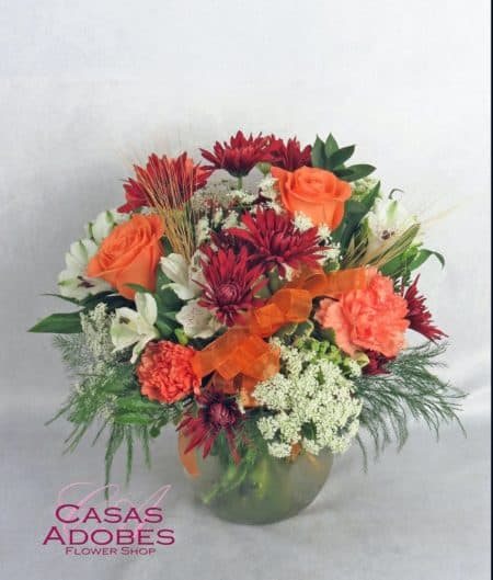 We have featured lovely autumn orange roses, burgundy cushion chrysanthemums, orange carnations, Queen Anne's lace and a delightful orange bow. This bouquet is ideal for any fall occasion, including birthdays, get well and thinking of you!